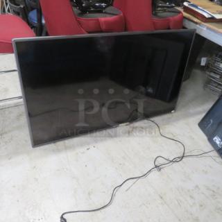 60-inch LG flatscreen TV, model unspecified, in used condition on a tiled floor with visible power cords.