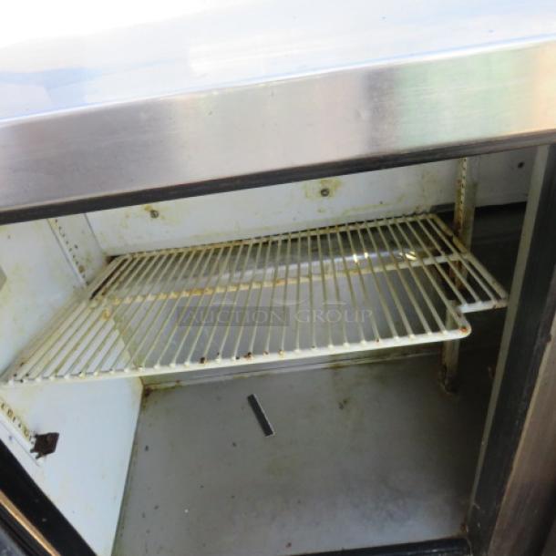 True TSSU-48-12 refrigerated prep table, 2-door unit on casters, includes 1 rack, 48"x30"x42.5", 115V, visible wear inside.