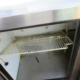 True TSSU-48-12 refrigerated prep table, 2-door unit on casters, includes 1 rack, 48"x30"x42.5", 115V, visible wear inside.