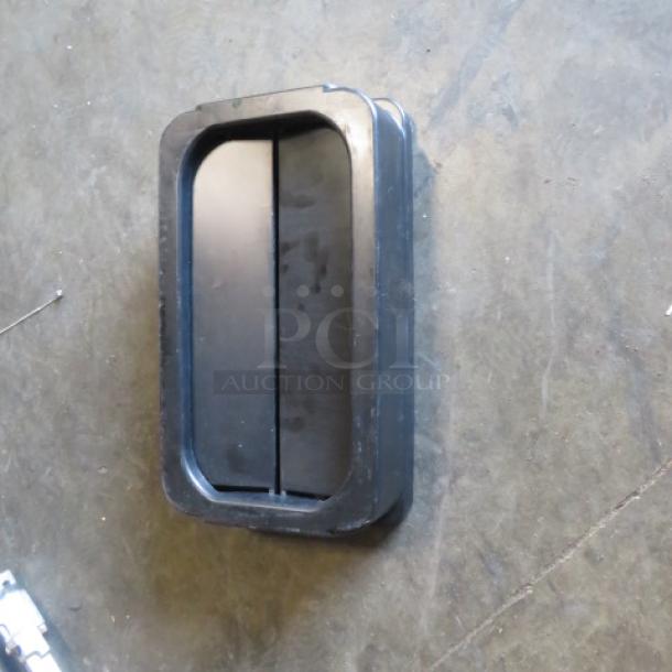 Black Slim Jim hinged lid, rectangular shape, made of durable plastic. Minor wear visible, ideal for waste container use.