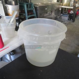 6 Quart Round Food Storage Container, clear plastic, with lid. Used condition, visible wear. Ideal for kitchen storage.