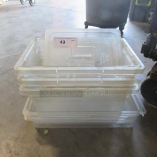 Stack of clear plastic storage bins, varying sizes, in used condition. Label shows lot number 49 for auction identification.