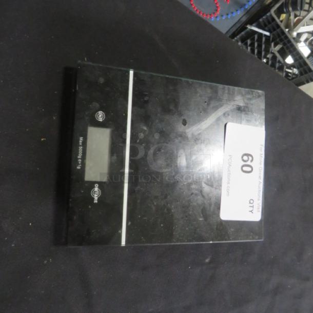 Digital kitchen scale with black surface and LCD display. Slight wear visible. Tag indicates item 60.