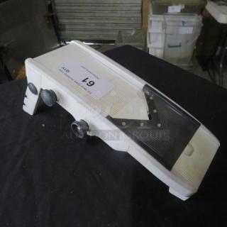 White mandolin slicer with adjustable thickness settings, stainless steel blades, and suction feet for stability. Model label "L9."