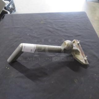 Metal griddle scraper with ergonomic handle and angled blade on display. Slight wear, auction tag visible on handle.