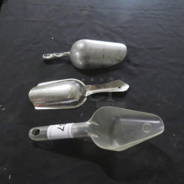 Assorted metal and plastic scoops, varying sizes. Visible label on plastic scoop reads "3XBID". Good condition.