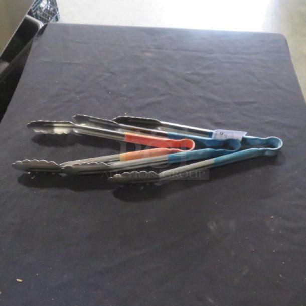 Assorted stainless steel tongs with colored grips, laying on a table, used condition, visible tag: "3XBID".