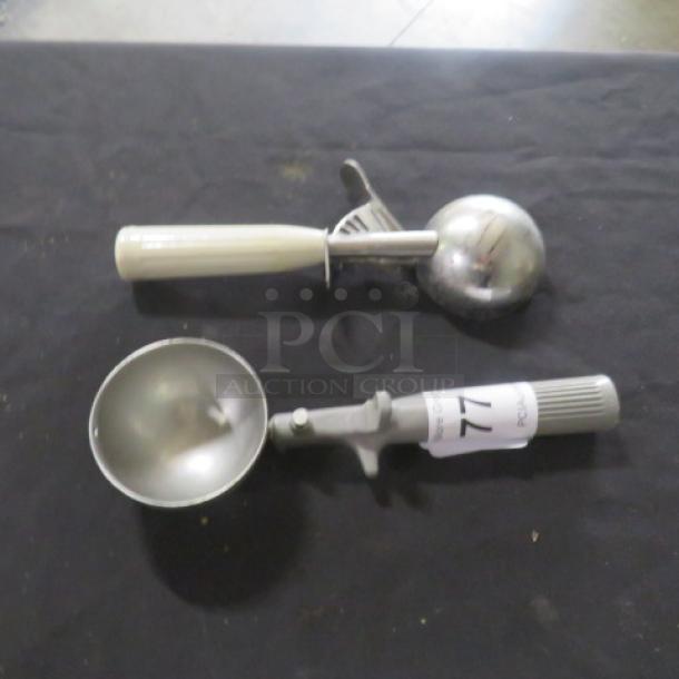 Two assorted dishers with stainless steel scoops and plastic handles, item tagged "77".
