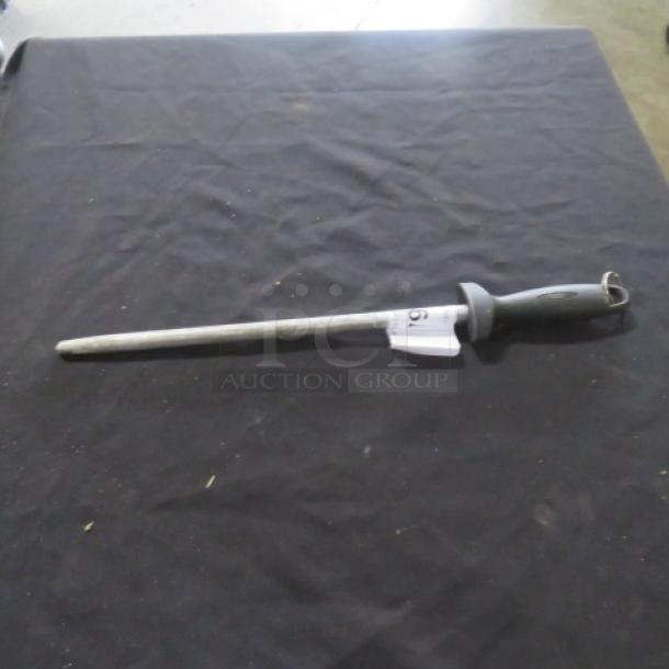 Steel knife sharpener with a black ergonomic handle, silver honing rod, and hanging loop, in good condition.