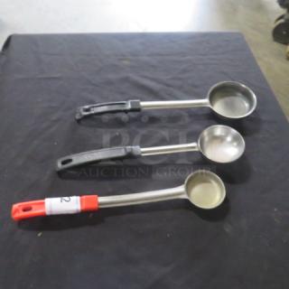 Three stainless steel spoodles with assorted handle colors on a black surface. Handles marked 3XBID.
