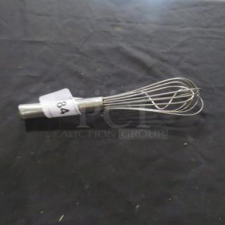 Stainless steel whisk with looped wire design and cylindrical handle, labeled with auction tag "84".