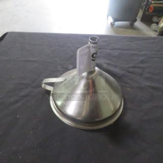 Stainless steel funnel with a handle on a black surface. Includes a paper tag attached to the spout. Good condition.