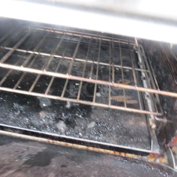 Southbend 10-burner natural gas range, stainless steel overshelf, 4 racks, on casters. Dimensions: 60.5x34x60. Present wear visible.