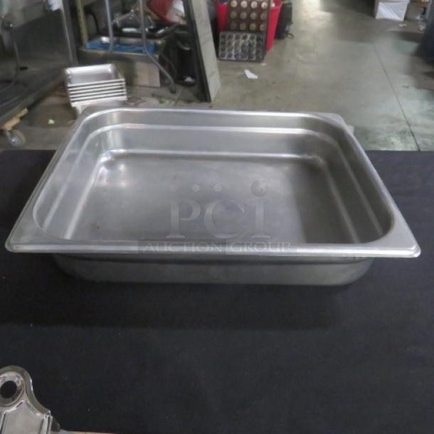 1/2 size 2.5" deep stainless steel hotel pan, used, minor scratches, ideal for catering or commercial kitchen use.