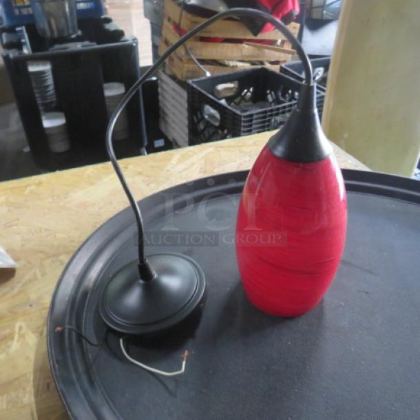 Red glass pendant light with black metal mount, model 2XBID. Good condition, sleek design, suitable for modern interiors.