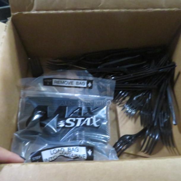 Box of assorted black plastic forks, featuring Max Stax branded packaging with clear "Remove Bag" and "Load Bag" labels.