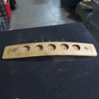 Wooden flight holder with five circular slots, branded "Código." Appears in good condition. Ideal for displaying tasting glasses.