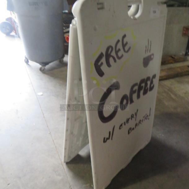 26x43 white sidewalk sign, A-frame style, with handwritten "Free Coffee" offer in black and yellow, slightly worn condition.