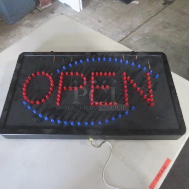 Illuminated "OPEN" sign, 22x13 inches, features red and blue bulbs. No cord included. Some wear visible on the frame.