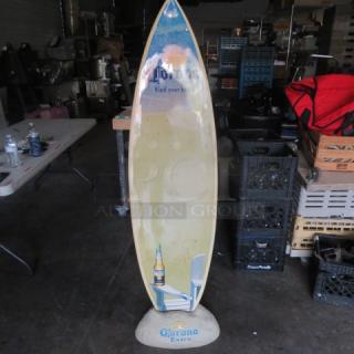 Corona surfboard with "Find your beach" design, includes Corona rock holder. Good condition, branding visible.