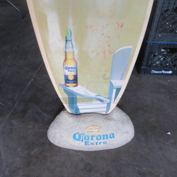 Corona surfboard with beach scene design and Corona bottle graphic. Comes with branded rock holder. Good condition.