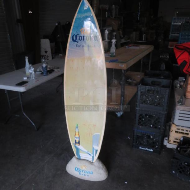 Corona surfboard with rock holder, branded design and logo; moderate wear; ideal for decor or collectors.