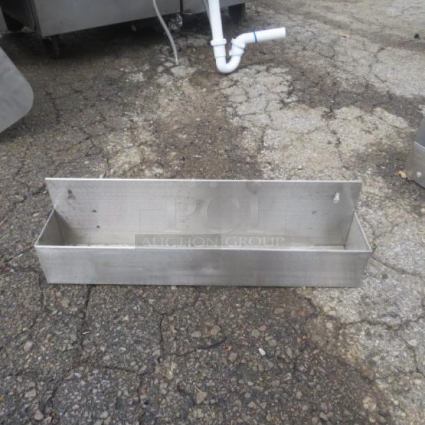 Stainless steel bottle rail, 22x4x6 inches, fair condition, designed for bar or kitchen use with wall-mount capability.