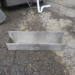 Stainless steel bottle rail, 22x4x6, in used condition, featuring a sturdy, rectangular design with visible mounting holes.