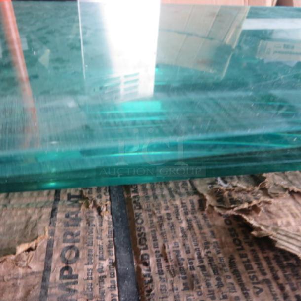 One 56x10 glass shelf, clear and rectangular, in good condition, showing thickness and smooth edges.