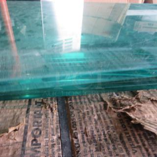 One 56x10 glass shelf, clear and rectangular, in good condition, showing thickness and smooth edges.