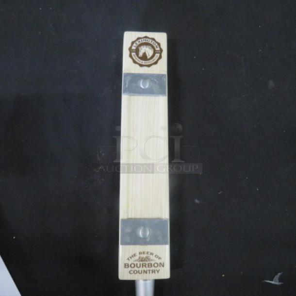 Wooden beer tap handle with "The Beer of Bourbon Country" label and engraved logo, metal accents, in good condition.