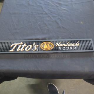 Tito's Handmade Vodka bar mat, black with logo and branding, rubber texture, used condition.