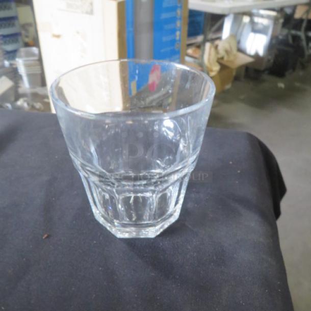 Clear rocks glass, 12XBID model, faceted design, excellent condition, no visible markings, on black fabric background.