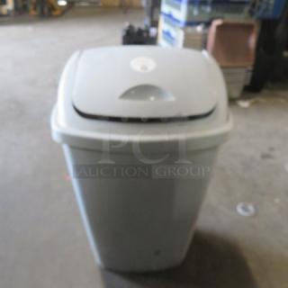 13.2-gallon trash can with swing top lid, light gray, used, sturdy plastic construction, suitable for home or office use.