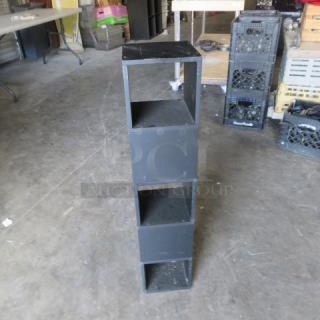 Black wooden shelf, 8x8x38 inches, four-tiered, used condition, suitable for small storage or display.