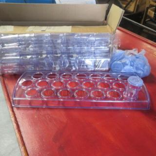 New Camel Horaca shot glass holder with 50 shot glasses and lids, on a red surface, showing packaging and contents.