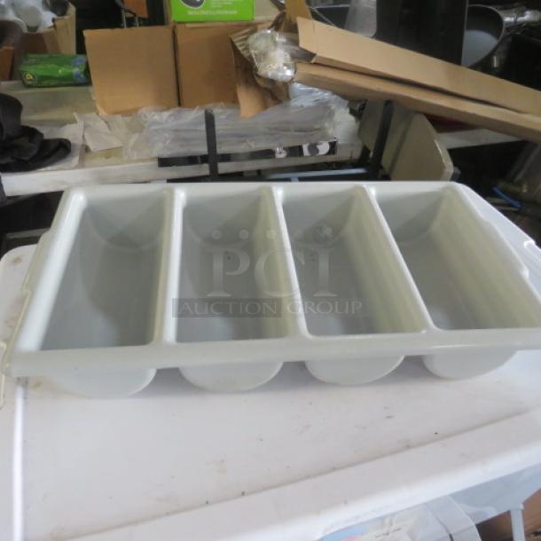 Four-compartment plastic flatware holder, white, used condition. Ideal for utensil organization in kitchens.