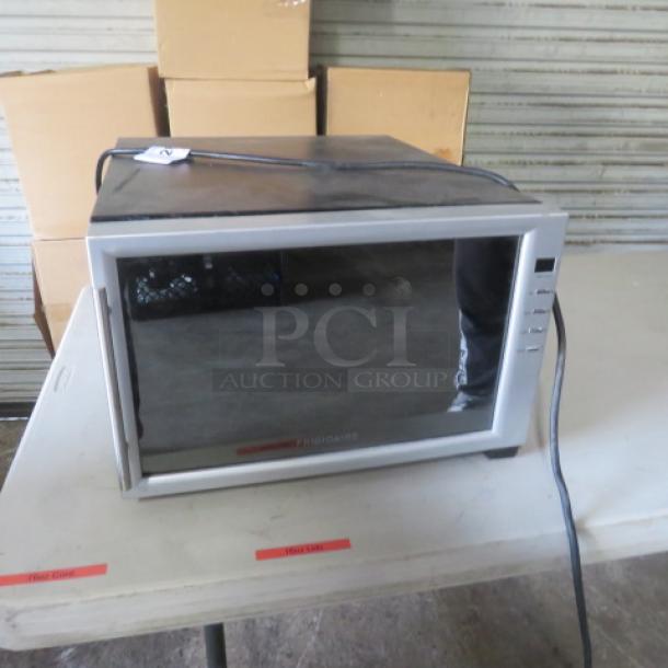 Frigidaire wine cooler, model FWC084HM, 110V, shown on tabletop. Good condition with visible brand label and power cord.