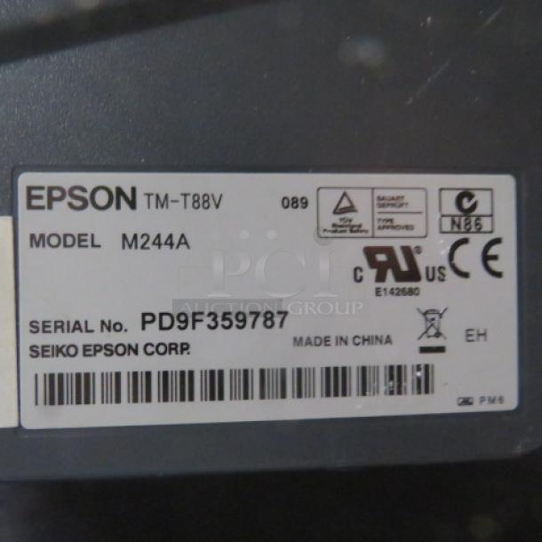 Epson thermal printer, Model M244A, with visible label showing serial number PD9F359787 and regulatory markings.