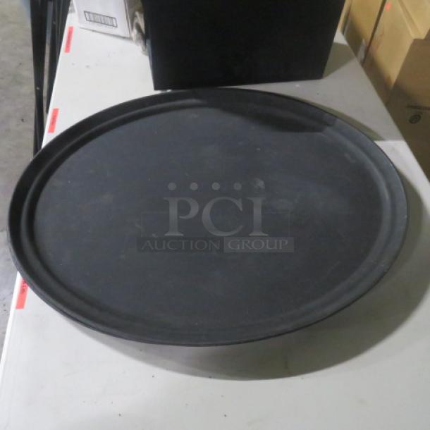 Black serving tray, 27x22 inches, round, lightly used condition, no visible markings or labels.