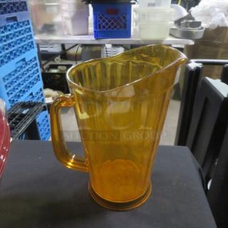 Amber polycarbonate pitcher with a handle, ribbed exterior design, used condition, suitable for beverages.