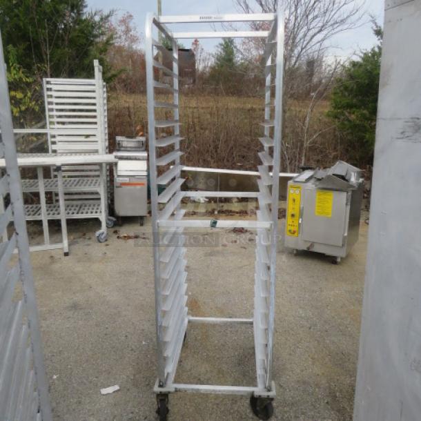 Aluminum speed rack on casters, 20.5x26x70 inches, in used condition. Holds multiple trays for kitchen storage, rust-resistant.