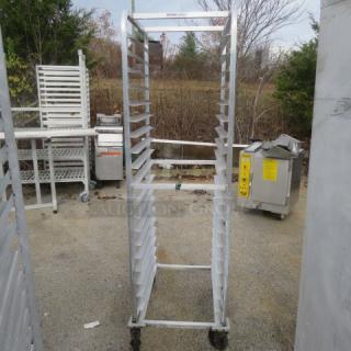 Aluminum speed rack on casters, 20.5x26x70 inches, in used condition. Holds multiple trays for kitchen storage, rust-resistant.
