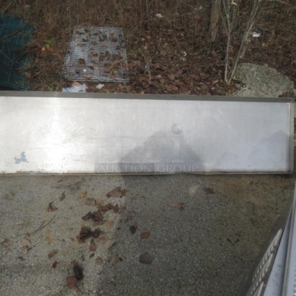 Stainless steel shelf with brackets, 84x22x20 inches, in used condition. Slight surface wear visible.