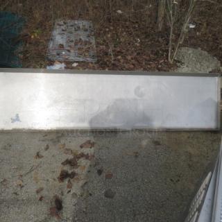 Stainless steel shelf with brackets, 84x22x20 inches, in used condition. Slight surface wear visible.