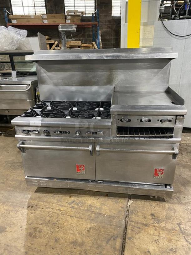 Wolf commercial stainless steel gas range with 6 burners, griddle, double oven, broiler, salamander shelf, and backsplash.