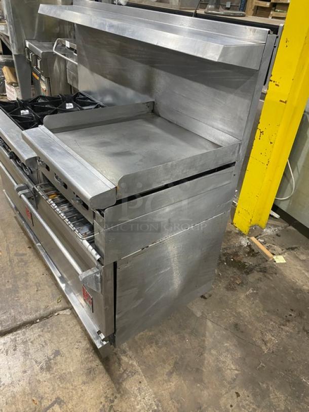 Wolf commercial stainless steel 6-burner range with griddle, double oven, broiler, backsplash, salamander shelf, and oven rack.