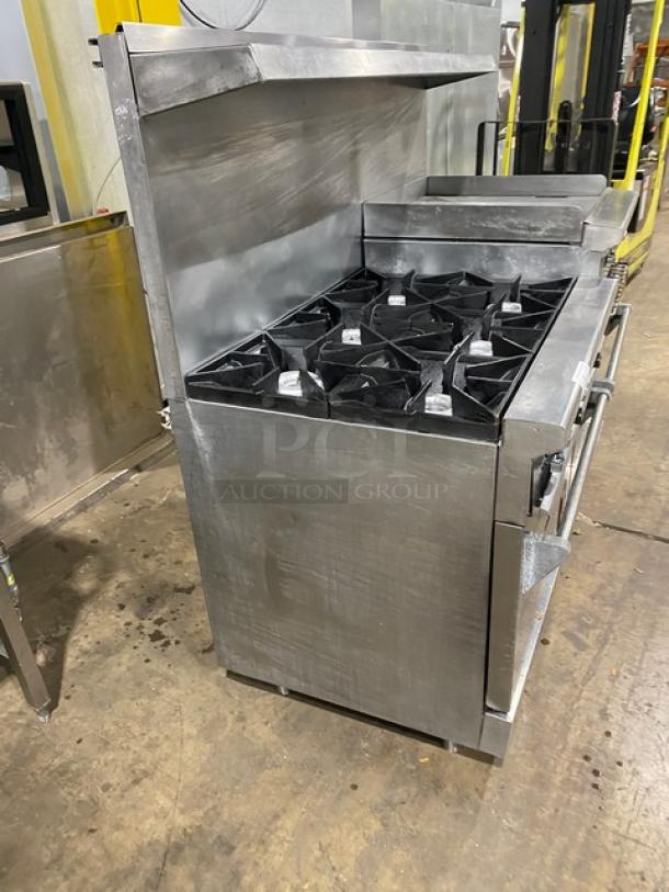 Wolf commercial stainless steel range with 6 burners, flat-griddle, double oven, broiler, and salamander shelf.