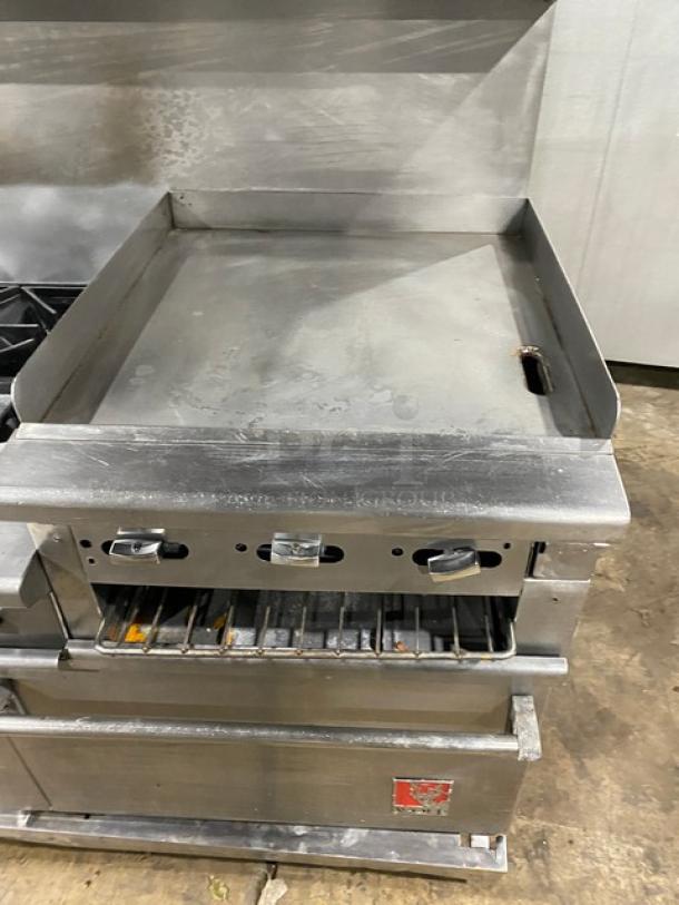Wolf commercial stainless steel range with 6-burner, raised flat griddle, double oven combo. Features broiler, salamander shelf.