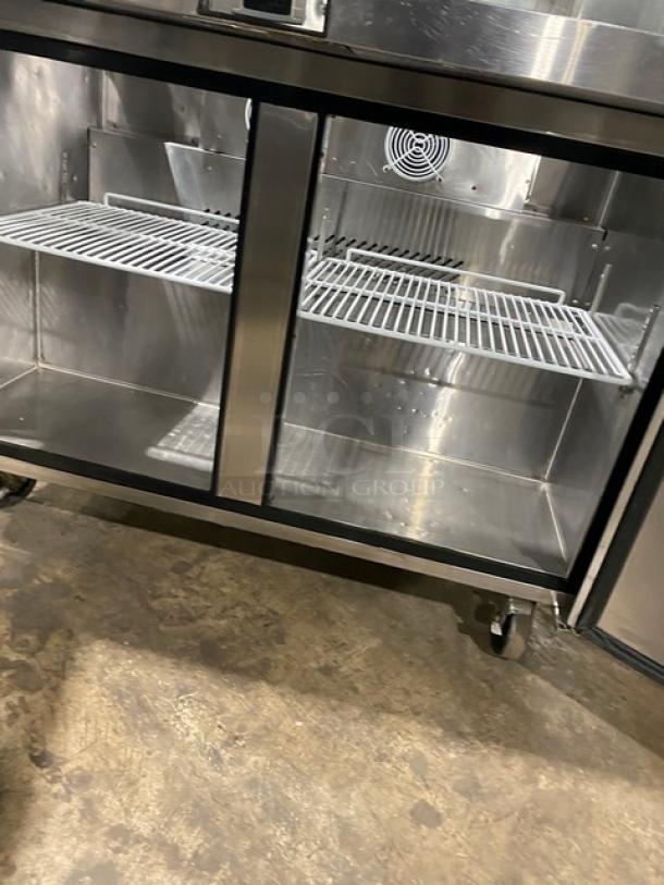 Atosa MSF8306 stainless steel 2-door refrigerated prep table with sneeze guard and poly-coated rack, on casters.